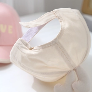 Close-up of adjustable velcro strap on beige cotton canvas baseball cap for toddlers