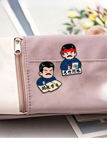 Cartoon Lu Xun enamel pin with study motivation text pinned to a purple canvas bag