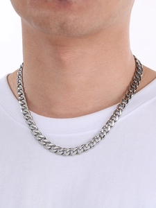 Close-up of a silver Cuban link chain necklace in stainless steel on a male model