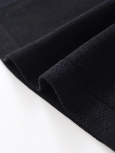 Detailed macro view of black knit fabric texture and high quality hem edge stitching