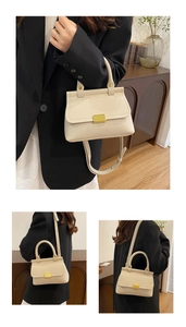 Détail d'un sac carré blanc crème avec texture litchi et fermoir en métal doré