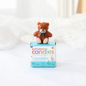 Detail of cute brown teddy bear birthday candle with blue square retail packaging box