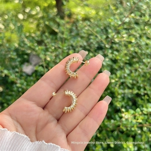 Détail de boucles d'oreilles en C plaquées or 18 carats avec pavé de zircons cubiques