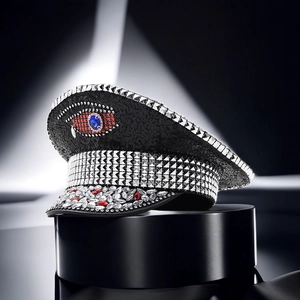 Macro shot of eye-shaped jewel design with sequins and rhinestones on black hat