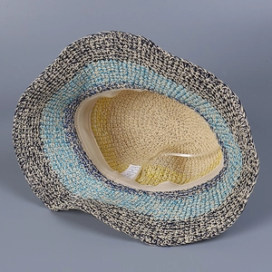 Detail of blue and white striped straw sun hat showing inner sweatband and care label