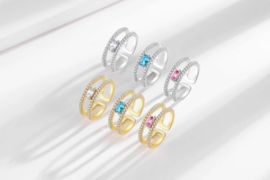 Detail view of double-layer square rings in gold and silver finish with zircon stones