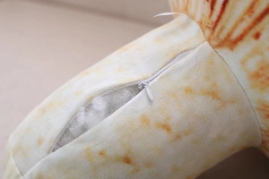 Close-up of the hidden zipper on the cartoon mushroom plush toy for easy cleaning