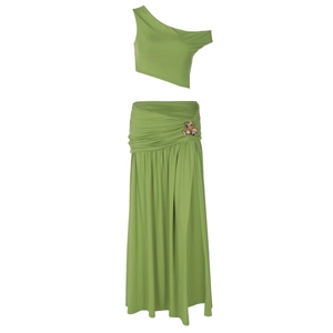 Detail of green two-piece set featuring a metal flower buckle on the high slit skirt