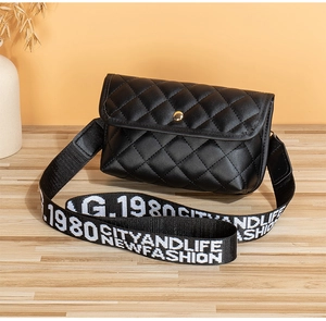 Close-up of black quilted small square bag with embroidered wide nylon shoulder strap