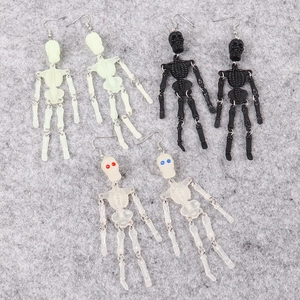 Macro view of articulated skeleton earrings in glow green, black, and transparent colors