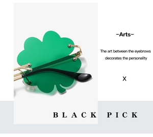 Detail of green shamrock shaped sunglasses with gold metal frame for holiday parties