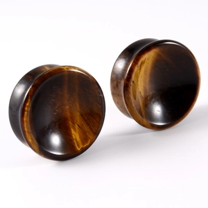 Macro shot of a pair of solid Tiger Eye stone ear gauges with golden chatoyancy finish