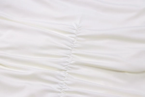Dettaglio macro del tessuto a maglia bianco con eleganti increspature e trama fine