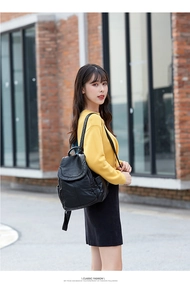 Vista esterna street style di uno zaino in morbida pelle nera con design a patta chic