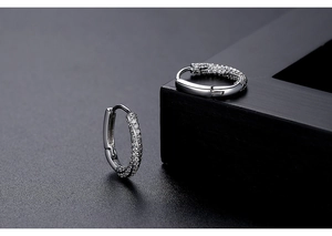 Macro shot of silver oval hoop earrings with shimmering pavé-set cubic zirconia crystals