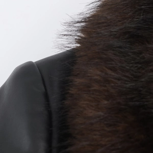 Close-up of the black faux leather shoulder and luxury dark brown faux fur collar detail