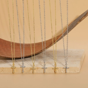Detailed display of six gold and silver cross necklaces with shimmering zircon accents