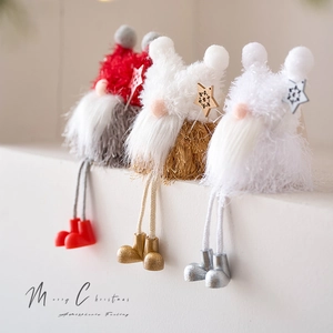 Three plush Christmas gnomes with long legs and knitted hats for festive desktop decoration