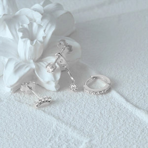 Detailed view of sterling silver earrings featuring crown stud and diamond accents