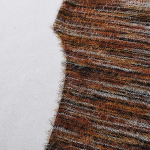 Close-up of textured knit fabric with orange and brown stripes and fuzzy wool finish