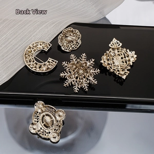 Detailed back view of vintage gold brooches showing clasp pins and hollow textures