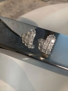 Macro shot of silver heart stud earring featuring micro-paved sparkling cubic zirconia