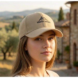 Detail of embroidered mountain peaks and Youth Dayoff text on beige baseball cap