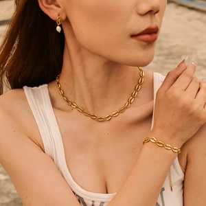 Golden shell jewelry set including necklace, earrings and bracelet on a model