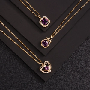 Three elegant gold necklaces with purple zircon pendants on a black textured background