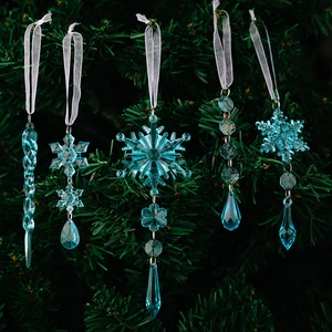 Detailed view of clear blue acrylic snowflake and icicle ornaments hanging on a Christmas tree