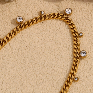 Detailed macro view of gold Cuban link necklace with circular zircon stone settings