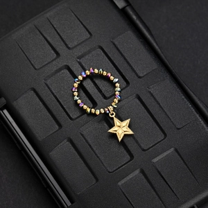 Detail of beaded elastic ring with gold star pendant and colorful faceted beads