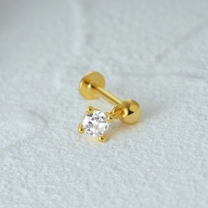 Detailed close-up of a gold S925 sterling silver star stud earring with a sparkling gem