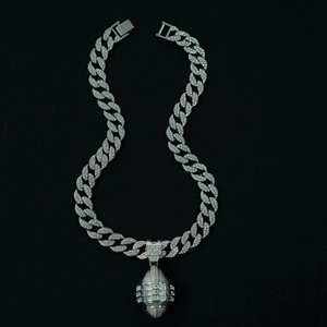 Macro shot of silver rugby pendant with clear crystals on iced out cuban chain