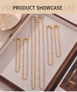 Detail of gold titanium steel jewelry set with colorful enamel dots on bead chains