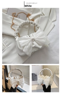 Close-up of white crossbody bag featuring a large decorative mesh bow and golden chain