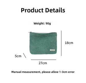 Detail of green corduroy makeup bag with striped texture and white branded woven label
