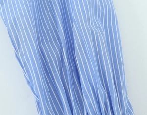 Close-up of blue and white vertical striped fabric texture on casual loose shirt
