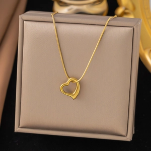 Collier minimaliste en or 18 carats avec pendentif cœur ajouré sur boîte à bijoux de luxe