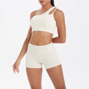Detail of one-shoulder yoga bra and high-waisted shorts set in cream white matte fabric
