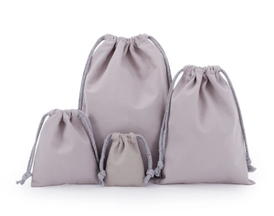 Set of four light gray drawstring pouches in various sizes for organized storage