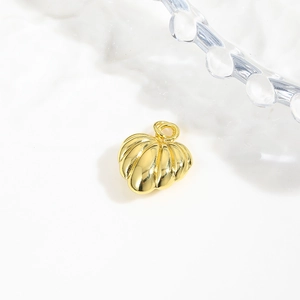 Detail shot of a hollow 18k gold plated shell pendant with textured metal surface