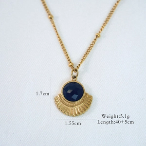 Detailed close-up of a 14K gold plated necklace with a fan-shaped blue gem pendant