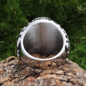Macro detail showing brushed inner band and thick texture of silver stainless steel ring