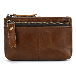 Macro view of dark brown genuine leather coin purse with vintage texture and metal zippers