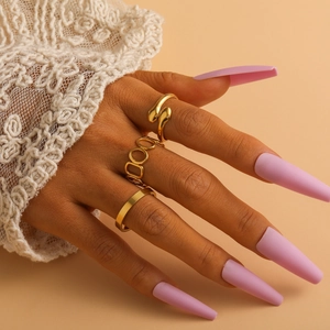 Detailed close-up of a three-piece gold ring set featuring snake and geometric hollow designs