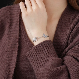 Close-up of a silver butterfly bracelet with sparkling zircons worn on a female wrist