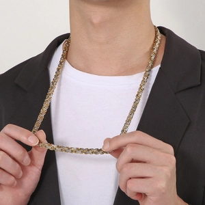 Gros plan d'un collier byzantin bicolore or et argent sur un mannequin masculin élégant