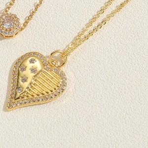 Detailed macro view of a gold heart pendant with sparkling crystals and ribbed texture
