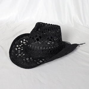 Detail of black woven straw cowboy hat featuring intricate hollowed-out ventilation patterns